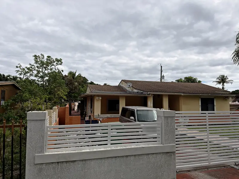 Before: the house from the street, with worn stucco on the columns